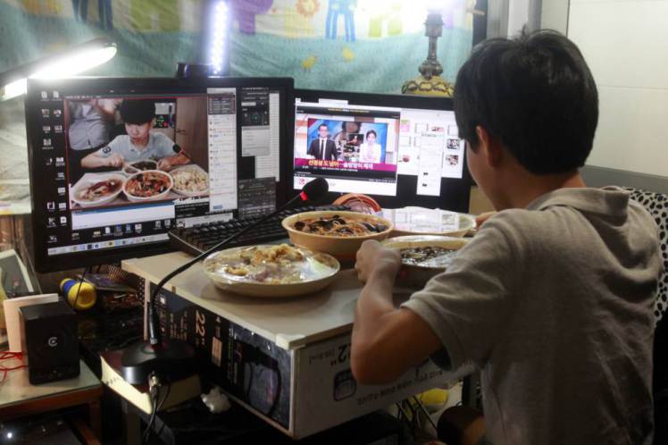 In this Monday, Aug. 17, 2015 photo, Kim Sung-jin, 14, broadcasts himself eating delivery Chinese food in his room at home in Bucheon, south of Seoul, South Korea. Every evening, he gorges on food as he chats before a live camera with hundreds, sometimes thousands, of teenagers watching. Thatís the show, and it makes Kim money: 2 million won ($1,700) in his most successful episode. Better known to his viewers by the nickname Patoo, he is one of the youngest broadcasters on Afreeca TV, an app for live-broadcasting video online launched in 2006. (AP Photo/Julie Yoon)