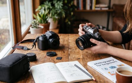 Ένα DSLR και μια mirrorless κάμερα πάνω σε ξύλινο τραπέζι, δίπλα σε σημειωματάριο με σημειώσεις για ISO και ταχύτητα κλείστρου
